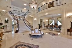 a large foyer with chandelier, marble floors and white walls on the second floor