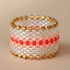 three rows of beaded bracelets with gold and red beads on each one side