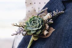 a boutonniere with succulents and flowers on the lapel