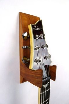 an electric guitar hanging on the wall with its neck and bridge made out of wood