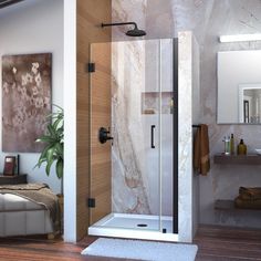 a bathroom with a walk in shower next to a bed