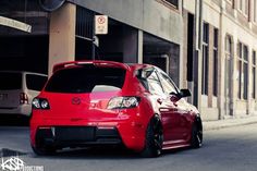 a red car parked in front of a building