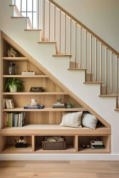 a book shelf under the stairs with books on it