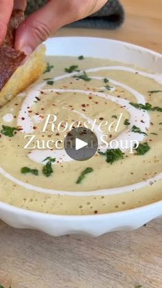 a person dipping something into a bowl of soup