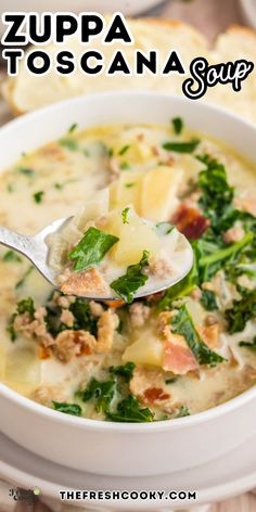 a bowl of zuppa toscana soup with a spoon in it and bread on the side