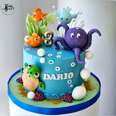 there is a blue cake decorated with sea animals and marine life on the bottom layer