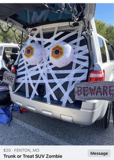 a trunk or treat suv with eyeballs on it's face and words that say beware