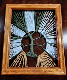 a wooden frame with some string art on the inside and in it's center