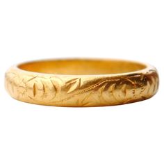 a gold wedding ring with leaves on it