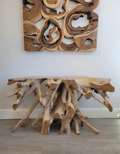 a large piece of driftwood sitting on top of a hard wood floor next to a wall