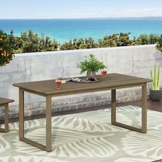 an outdoor table and two chairs on a patio overlooking the ocean