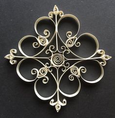 a silver brooch sitting on top of a black surface