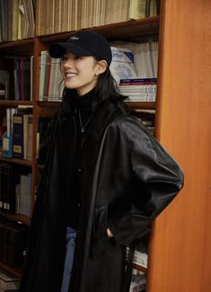 a woman standing in front of a book shelf