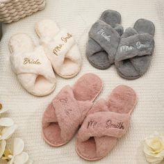 four pairs of slippers with personalized names on them sitting on a white blanket