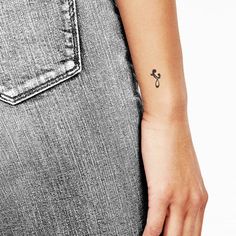 a person with a small tattoo on their left arm and the other hand behind her back