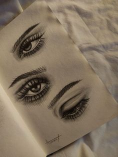 an open book with drawings of eyes on it