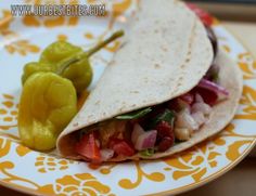 there is a tortilla on the plate with peppers and jalapenos