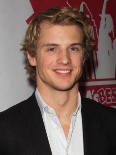 a young man in a suit smiling for the camera