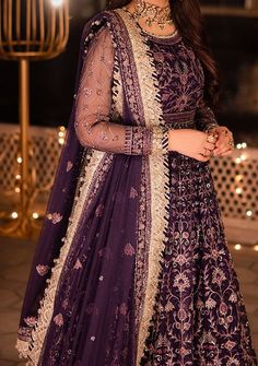 Introducing our New collection 'Chandni Raatein' by Asim Jofa designed to make you look and feel your best. Swathed in the mystique of twilight, this dress is a purple dream woven into existence. Champagne gold zari, like sunbeams kissing a lavender sky, are studded with stardust-like sequins. Threads in mauve and deep purple hues dance in harmony, creating a masterpiece of color. The embroidered dupatta, a wispy cloud of enchantment, finishes this ensemble with the grace of a fairytale ending. Embroidered Front and Back Bodice With Bodice Hem on Net Embroidered Kalis for Peshwas on Net Embroidered Border for Hemline of Peshwas on Net Embroidered Sleeves With Border on Net Embroidered Dupatta on Net With 4 Side Borders Color: There might be slight color variation due to lighting and flashe Purple Dabka Anarkali Set For Navratri, Purple Anarkali Set With Dabka Embroidery, Purple Dabka Detailed Anarkali Set, Purple Dabka Anarkali Set, Purple Georgette Anarkali Set With Dabka, Designer Dabka Gown For Navratri, Navratri Designer Gown With Dabka Detailing, Anarkali Purple Choli For Eid, Purple Anarkali Choli For Eid