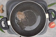 a pan with food cooking in it on top of a table next to vegetables and utensils