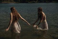 two women in the water holding hands