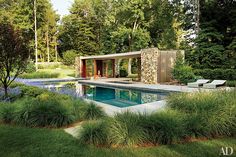 an outdoor swimming pool surrounded by grass and trees