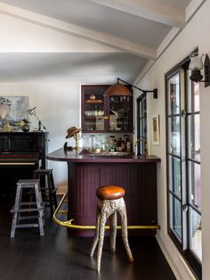 a bar with stools in front of it and a piano on the other side