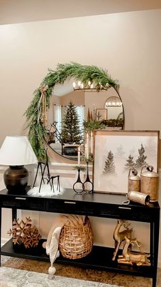 a table with christmas decorations on it in front of a mirror and other decor items