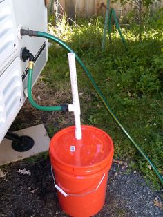 an orange bucket with a hose attached to it