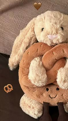 a stuffed bunny holding a large pretzel