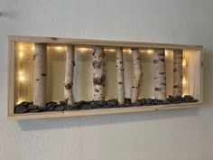 some lights are hanging on the side of a wall with trees and rocks in it