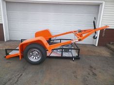 an orange trailer parked in front of a garage