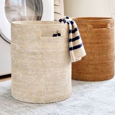 two baskets sitting on top of a rug next to a dryer and washing machine