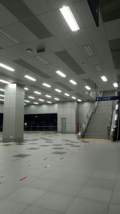 an empty parking garage with stairs and lights