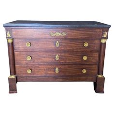 an antique chest of drawers with brass hardware and black marble top, circa to the early 20th century