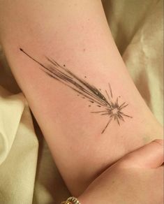 a woman's arm with a tattoo on it that has a star burst coming out of it