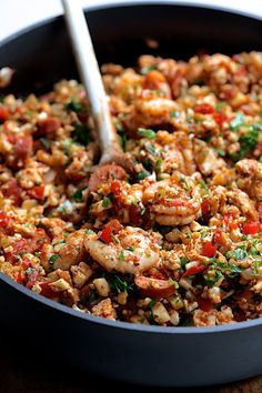 a skillet filled with shrimp and vegetables