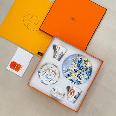 an orange box with some plates and spoons in it