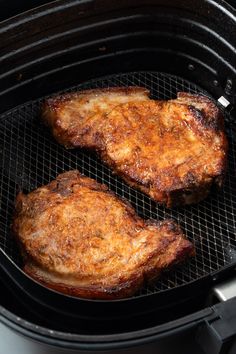 two pieces of meat cooking in an air fryer