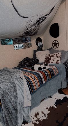 a bed room with a neatly made bed and cowhide rugs on the floor