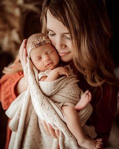 a woman holding a baby wrapped in a blanket