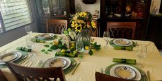 a dining room table set with plates and place settings