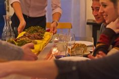 a group of people sitting around a table with food