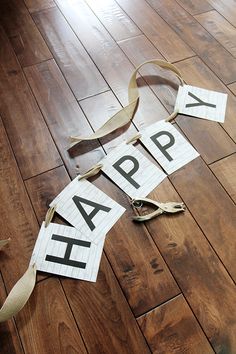 a happy birthday sign on the floor with ribbon around it that says happy written in black and white letters