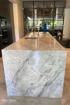 a kitchen with marble counter tops and stainless steel appliances in the backround area