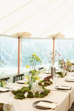 the table is set with moss and flowers