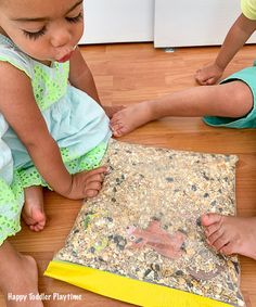 two children are playing with an object on the floor