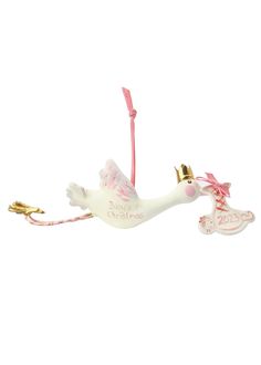 a white ceramic ornament with a pink ribbon and angel on it's side