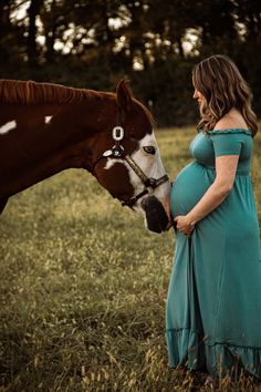 a pregnant woman standing next to a brown and white horse