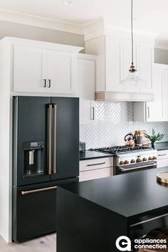 a kitchen with white cabinets and black counter tops, an island in the middle is surrounded by stools